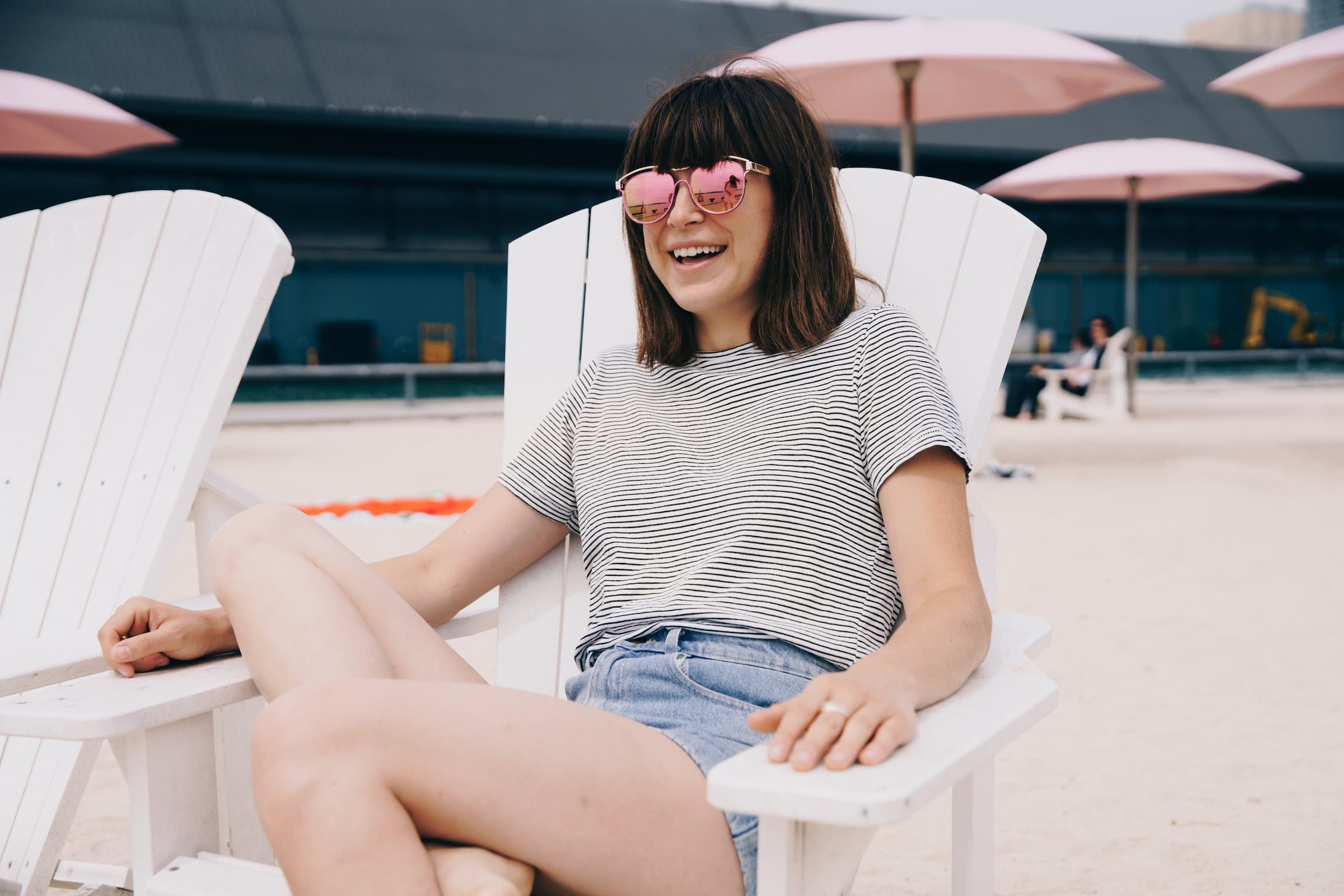 a-person-sitting-in-a-wooden-chair-smiling-on-a-beach-learning-how-to-enjoy-life