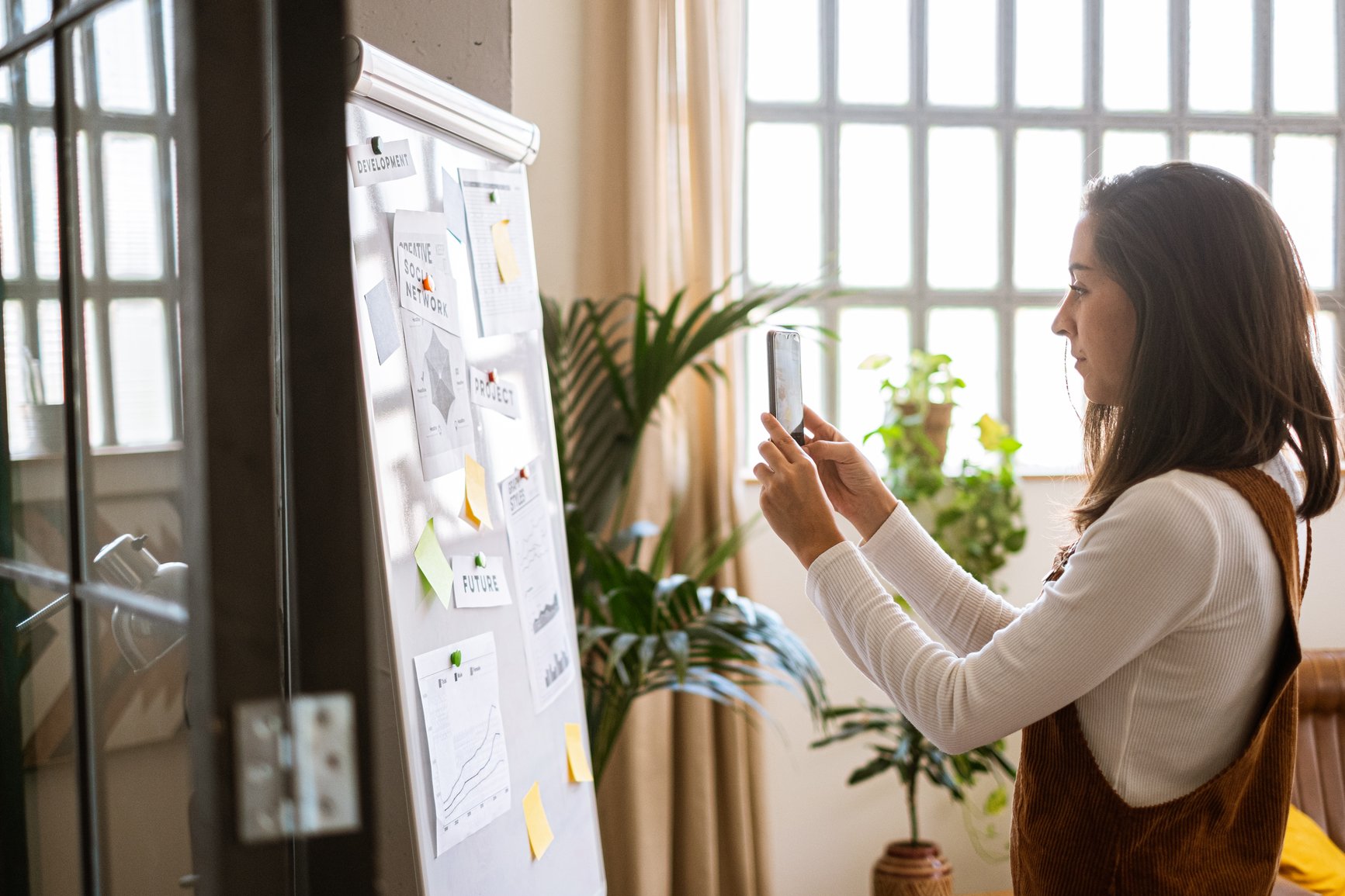Concentrating-female-taking-a-picture-of-a-flip-chart-in-a-workspace-how-to-build-confidence