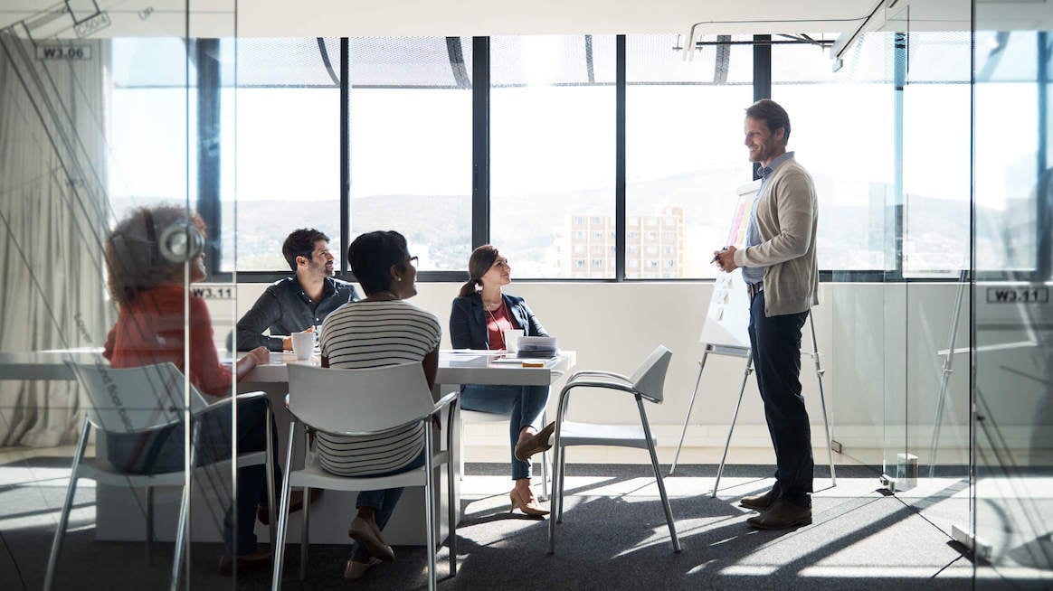 constructive-feedback-examples-man-standing-at-table-presenting