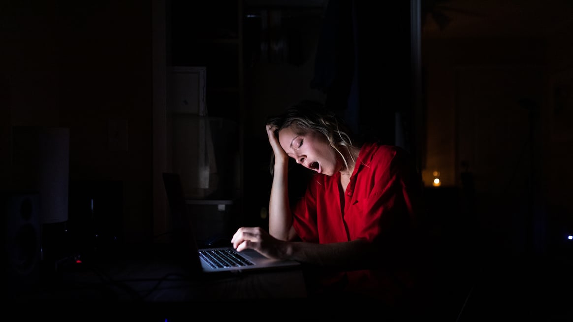 woman-yawns-exhausted-at-computer-upside-of-reducing-burnout